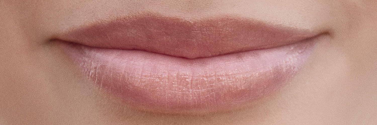 Gros plan sur des lèvres. Les lèvres sont recouvertes d'un baume à lèvres teinté rose.