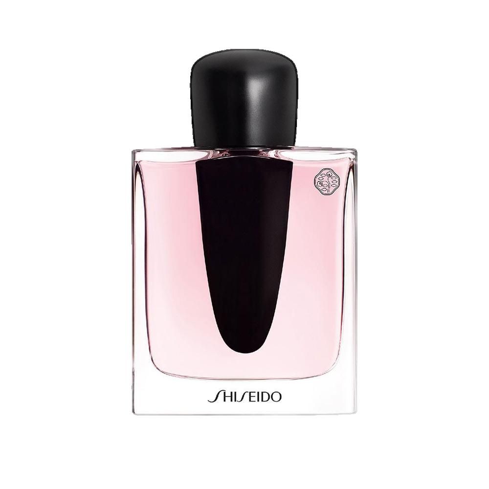 Flacon de parfum avec bouchon noir et liquide rose. Inscription SHISEIDO.