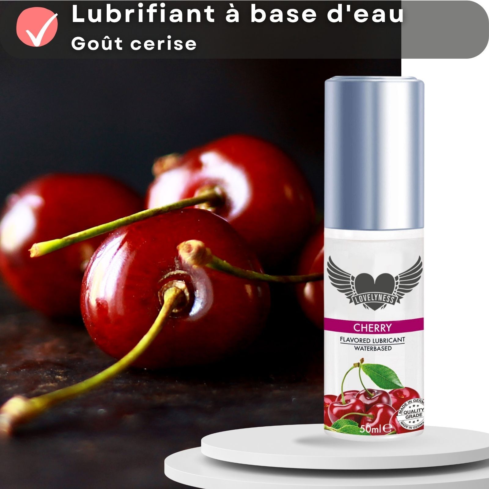 Flacon de lubrifiant aromatisé cerise. Cerises représentées. Texte : Lubrifiant à base d'eau, goût cerise.