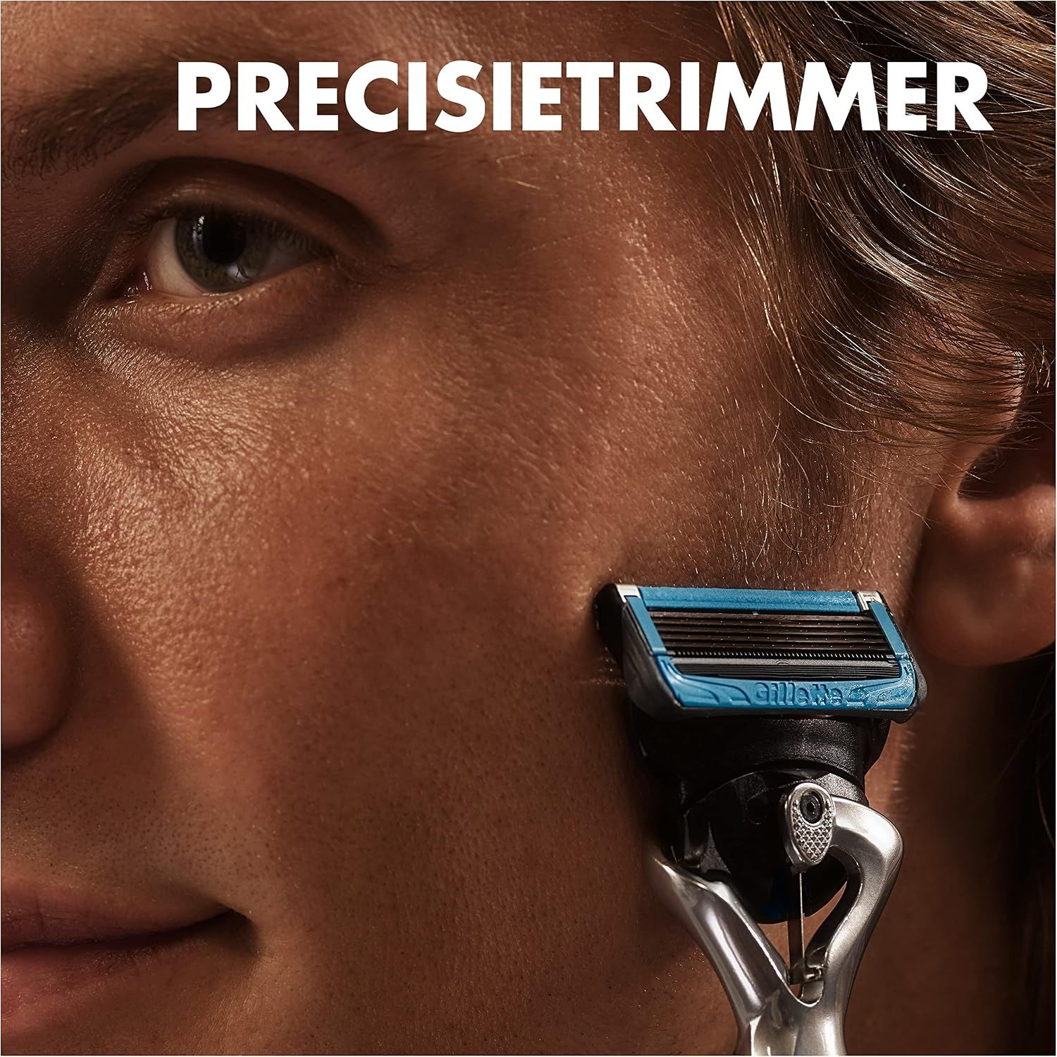 Gillette precisietrimmer met blauw handvat en zilverkleurig metalen handvat, toegepast op de huid.