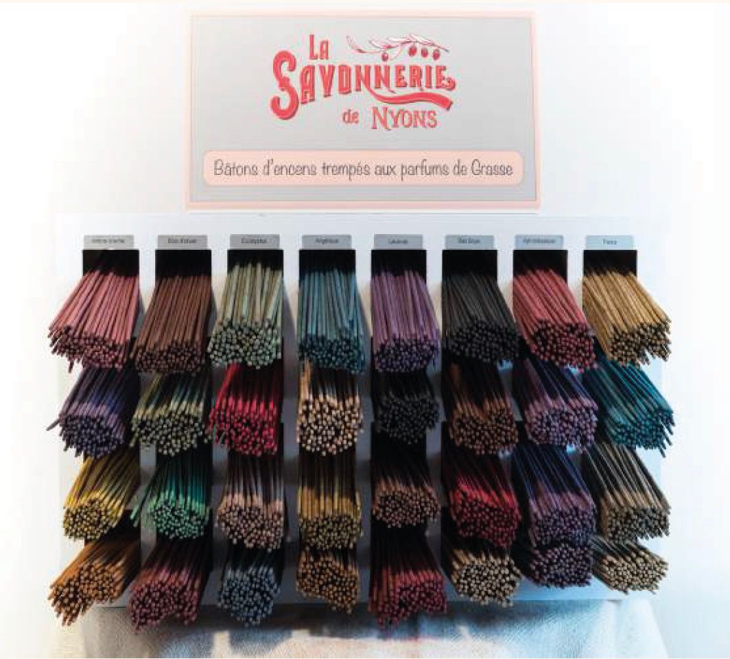 Presentatie van wierookstokjes. Meerdere bundels in verschillende kleuren. Boven: logo "La Savonnerie de Nyons".