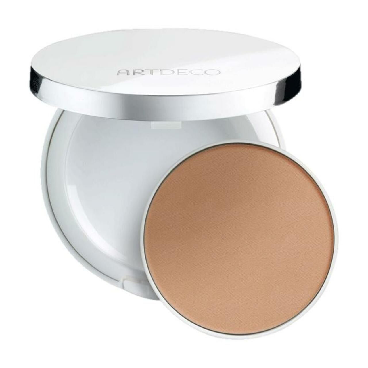 Witte, ronde houder met open deksel. Bevat een ronde, beige foundation. Opschrift "ARTDECO" op deksel.