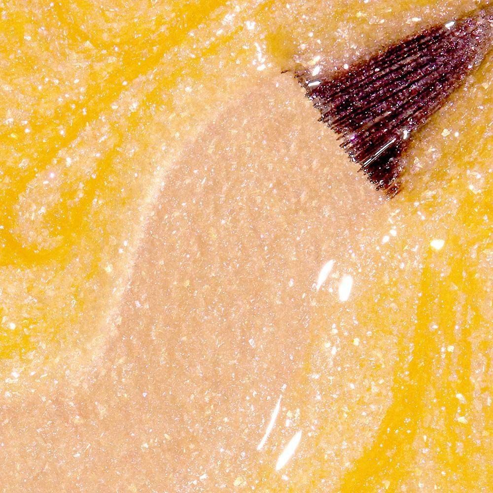 Nagellak applicator op gele nagellak. De borstel is bedekt met nagellak. Close-up.
