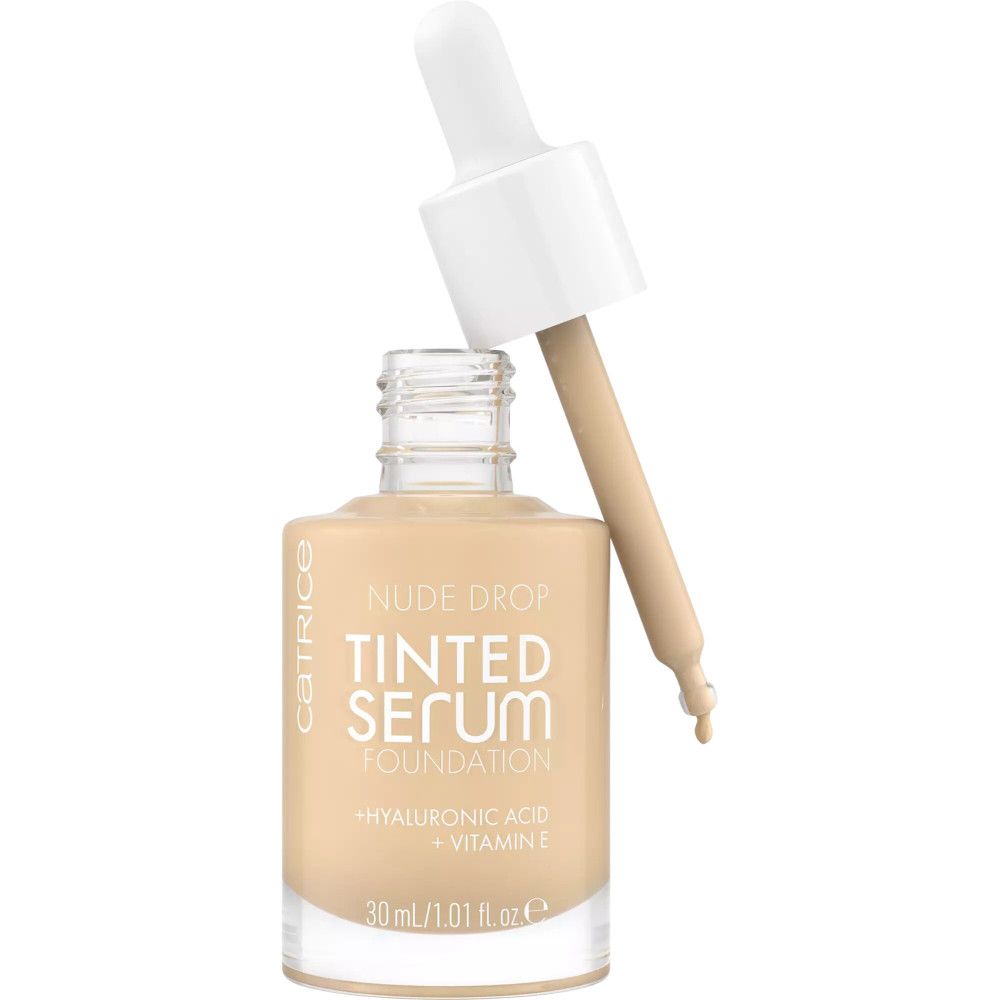 Flacon de sérum teinté avec pipette. Inscription : Nude Drop, Tinted Serum Foundation, Acide hyaluronique + Vitamine E.