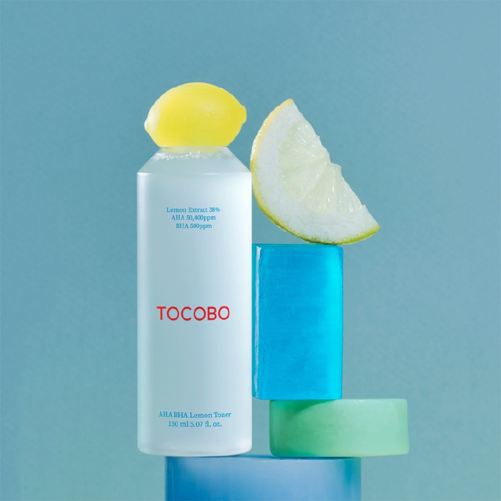 Citroen tonerfles met gele dop en geometrische vormen. Opschrift TOCOBO. Tekst: AHA BHA Lemon Toner, 150 ml.