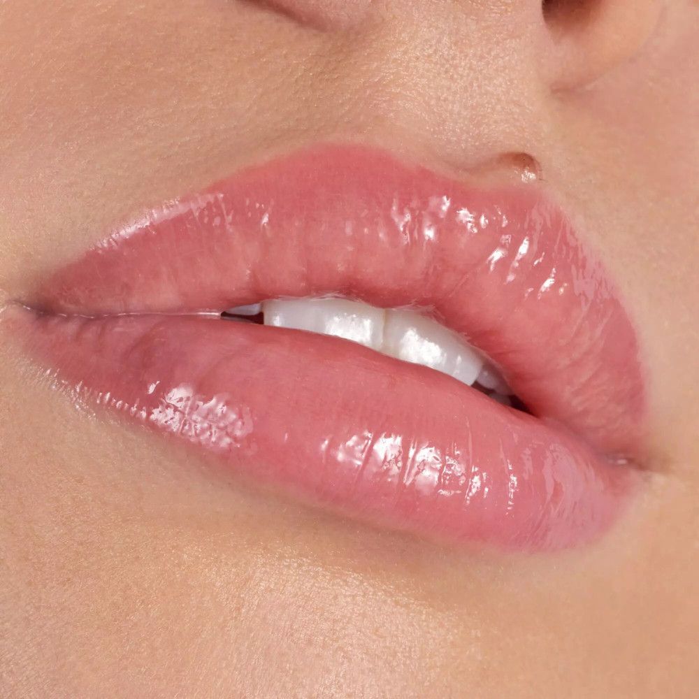Close-up van lippen met glanzende lipgloss. Roze tint. Open mond.