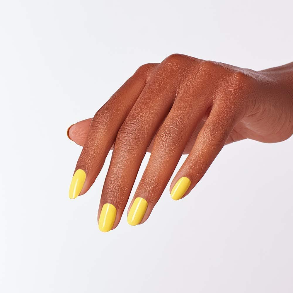 Main avec vernis à ongles jaune. Ongles vernis, peau claire.