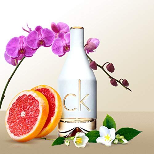 Flacon de parfum avec orchidées, pamplemousse et fleurs de jasmin.
