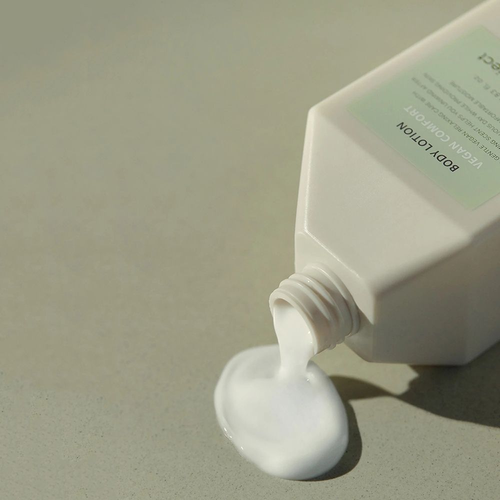 Witte lotion die uit een fles stroomt. Groene achtergrond. Productnaam niet zichtbaar.