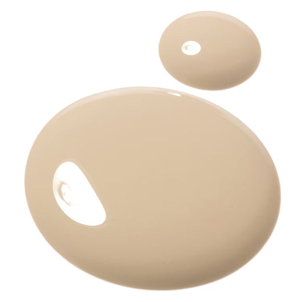 Twee klodders beige foundation. Ronde vorm, glad oppervlak. Op witte achtergrond.