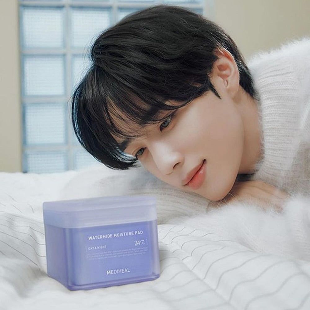 Un homme est allongé à côté d'une boîte carrée. Inscription : Watermide Moisture Pad, Day & Night, 24/7, Mediheal. Boîte violette.