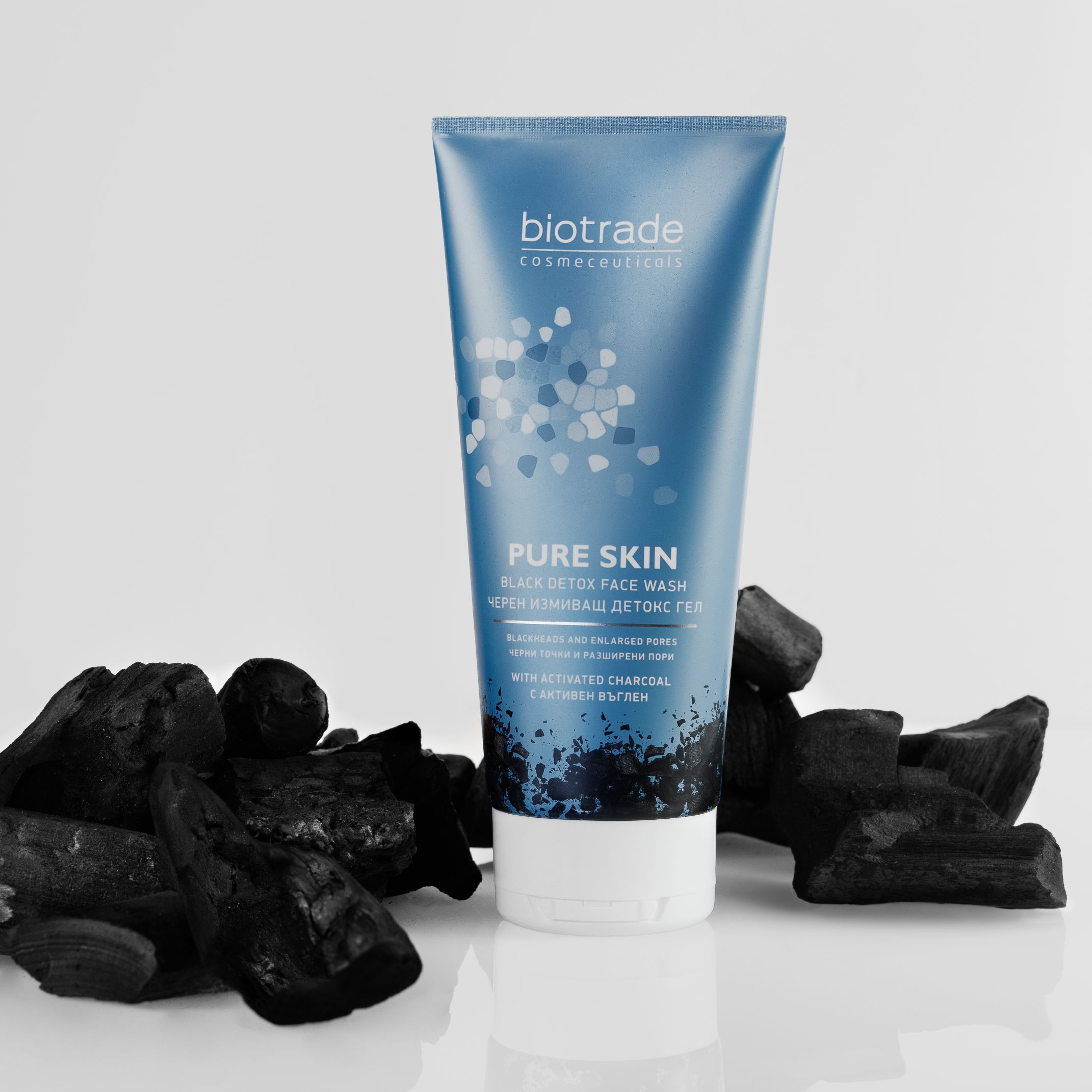 Blauwe tube met witte dop, omringd door houtskool. Opschrift: Biotrade, Pure Skin Black Detox Face Wash.