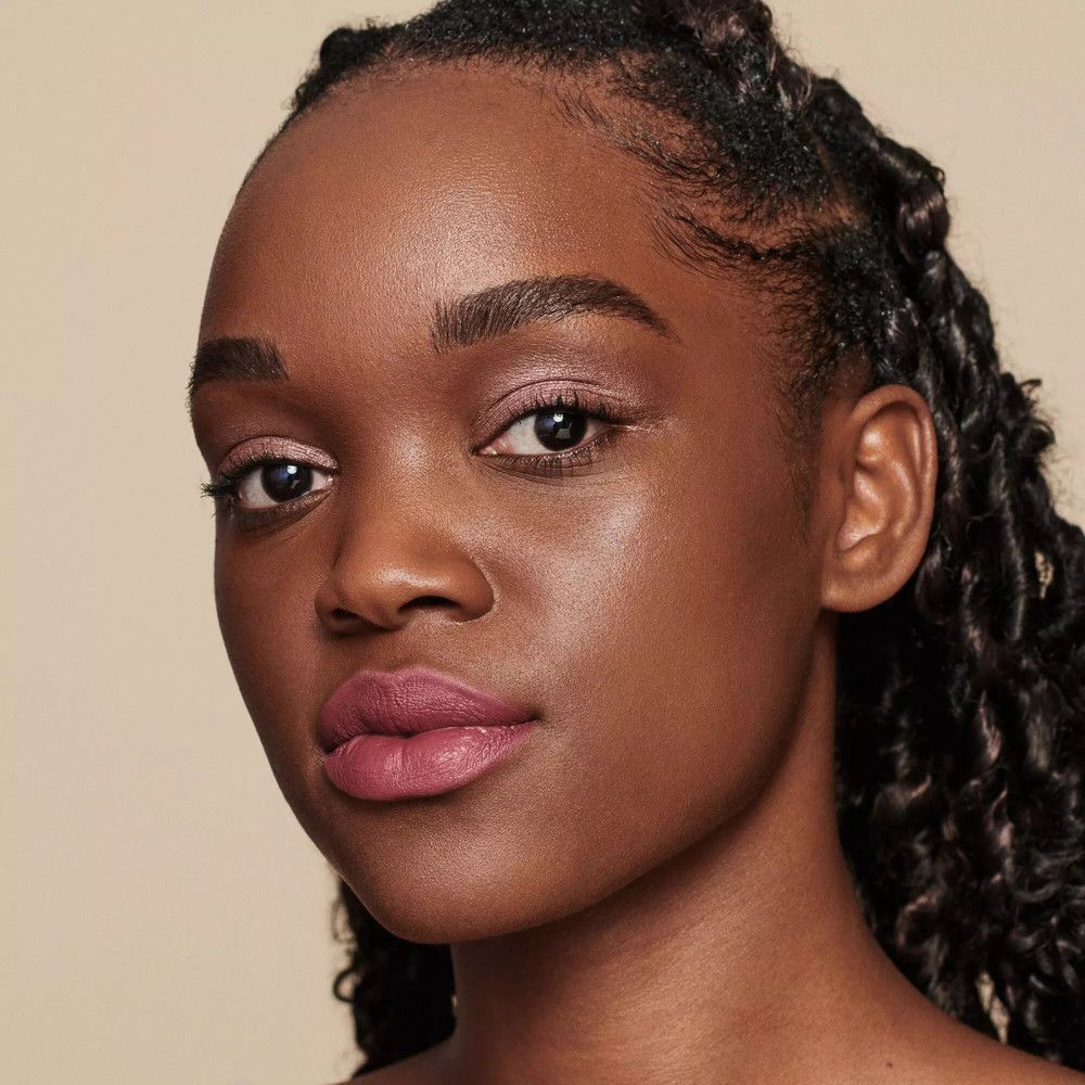 Gros plan d'un visage maquillé. Les lèvres et les yeux sont maquillés avec des tons roses.