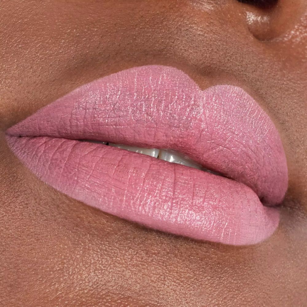 Gros plan sur des lèvres maquillées avec du rouge à lèvres rose.