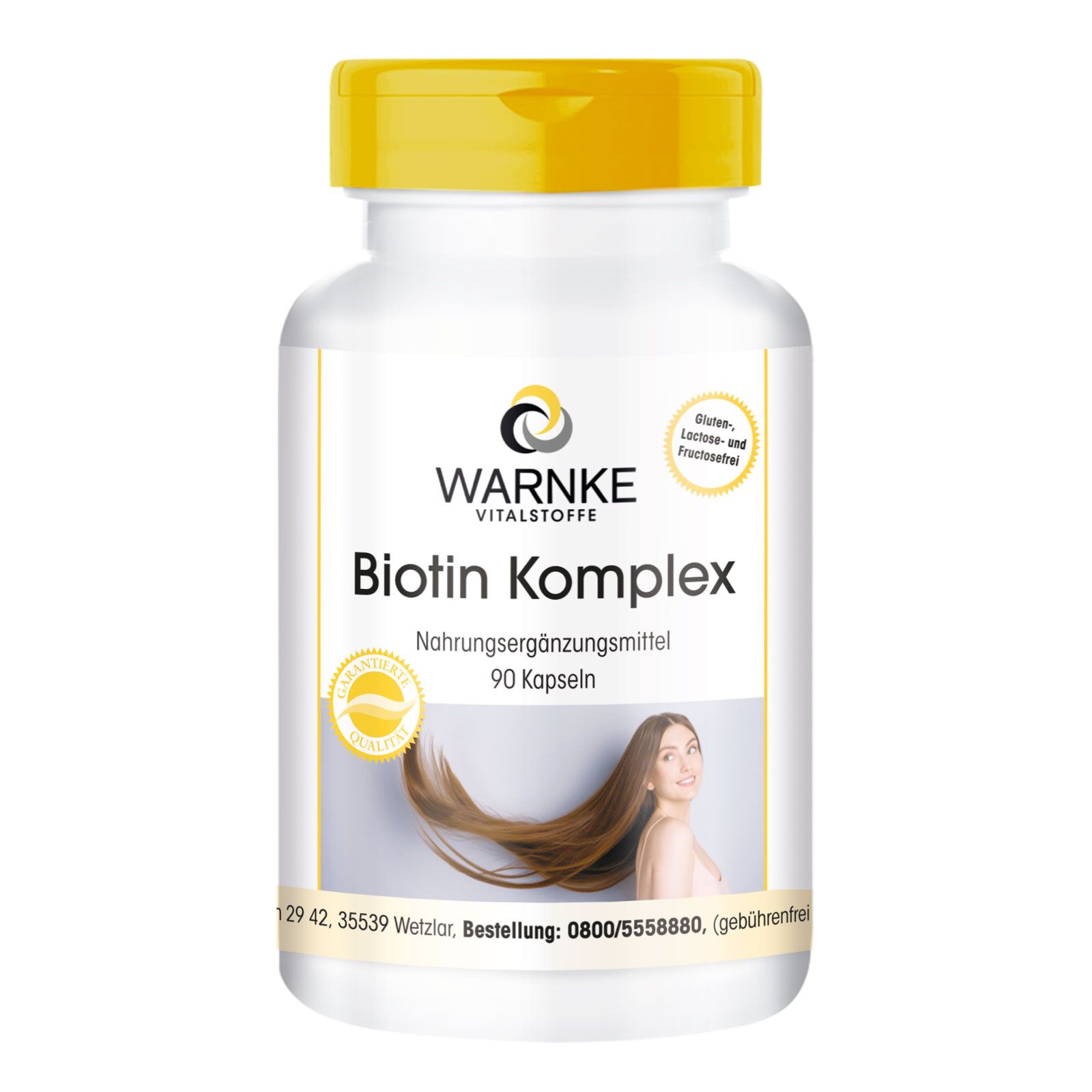 Flacon blanc à bouchon jaune. Inscription: Warnke Vitalstoffe, Biotin Komplex, 90 capsules. Logo et femme aux cheveux longs.