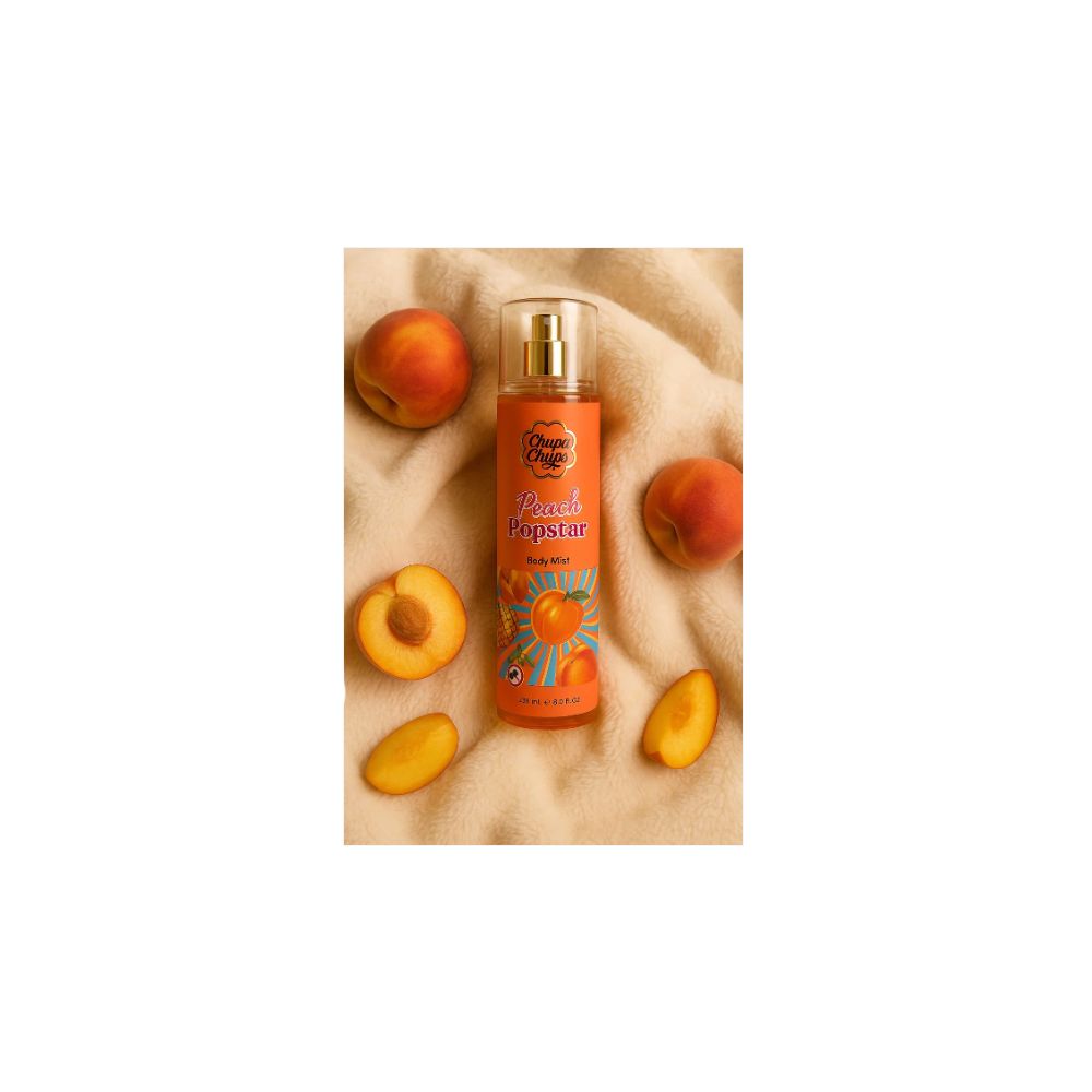 Brume pour le corps Peach Popstar. Flacon orange avec vaporisateur. Entouré de pêches.
