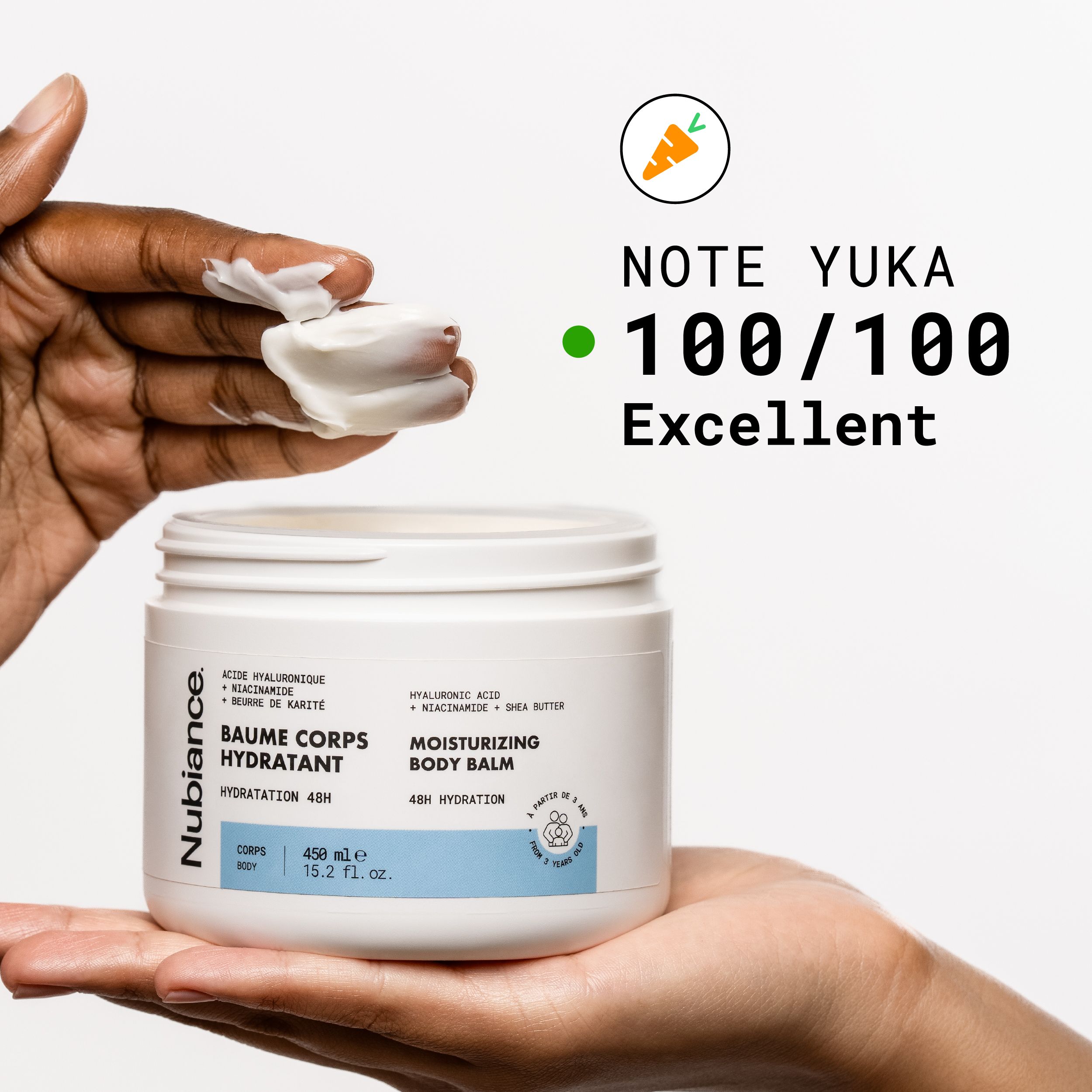 Hand die een pot „Baume Corps Hydratant“ vasthoudt. Yuka-score 100/100. Crème op de hand.
