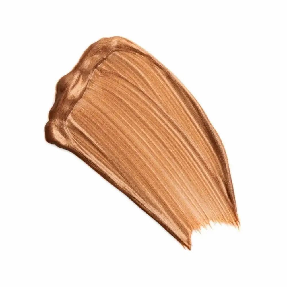 Gouden bronzer-veeg op witte achtergrond. Textuur zichtbaar.