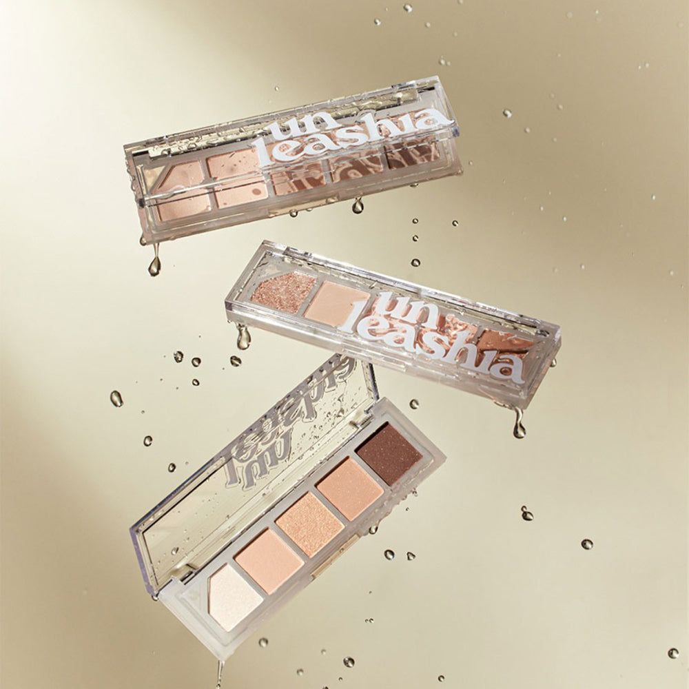 Trois palettes UNLEASHIA Mood Shower transparentes, avec fards à paupières. Gouttes d'eau. Nom du produit sur les palettes.