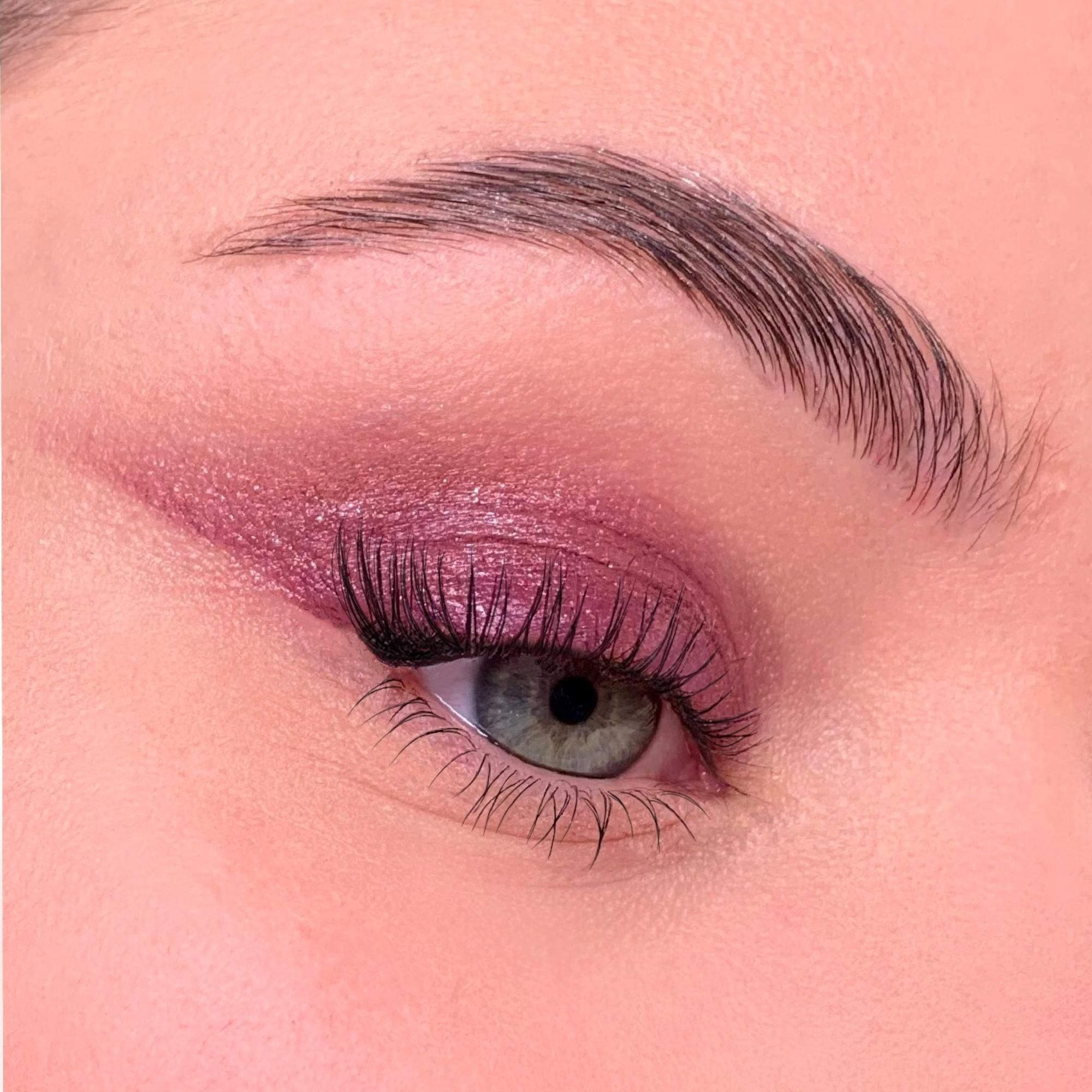 Gros plan sur un œil avec fard à paupières. Paupière mise en valeur avec un fard à paupières rose. Cils allongés.