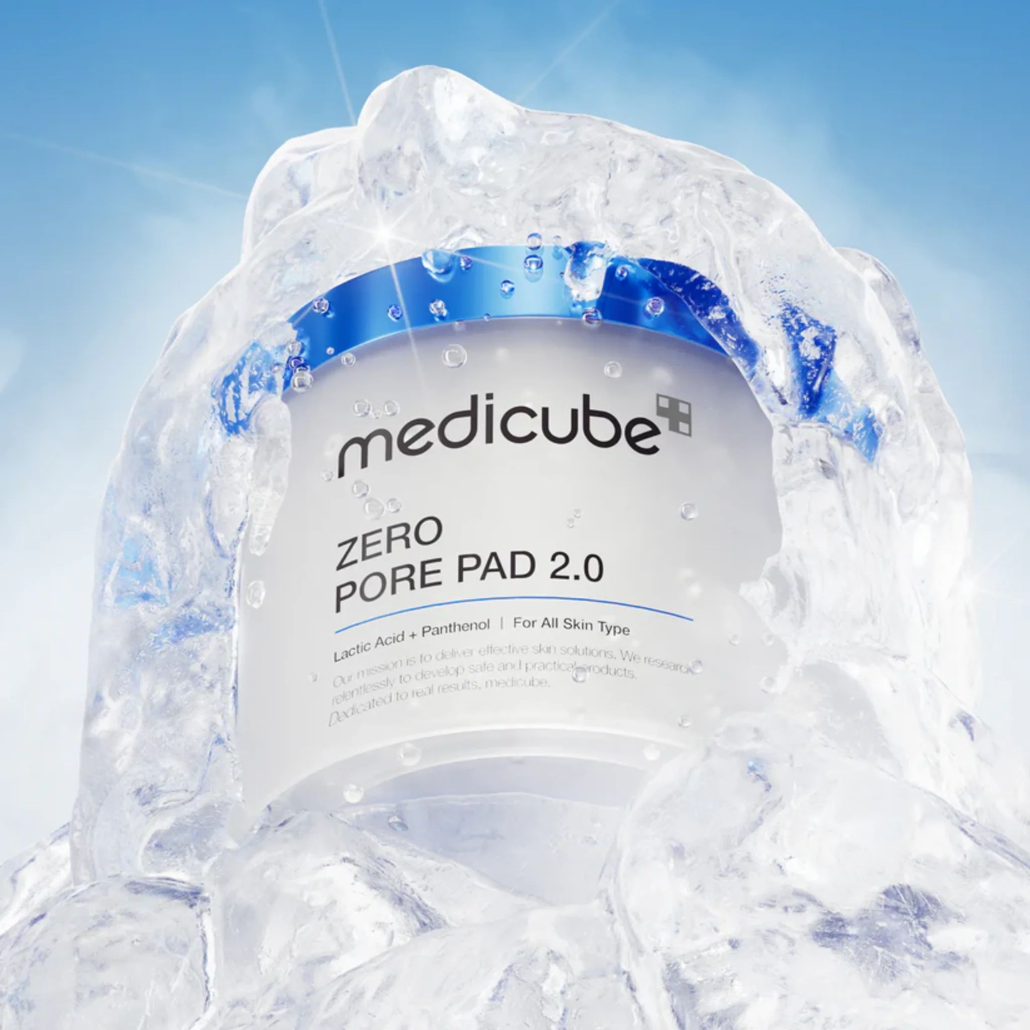Contenant blanc avec couvercle bleu dans la glace. Inscriptions: medicube, ZERO PORE PAD 2.0. Texte sur ingrédients et type de peau.