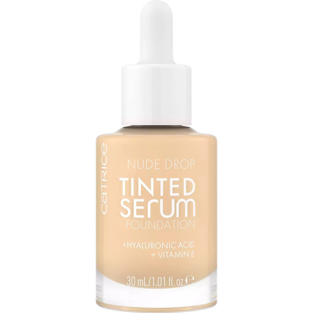 Flacon en verre de Catrice Nude Drop Teinté Sérum Foundation avec pipette. Inscription : TINTED SERUM FOUNDATION, Acide hyaluronique + Vitamine E.