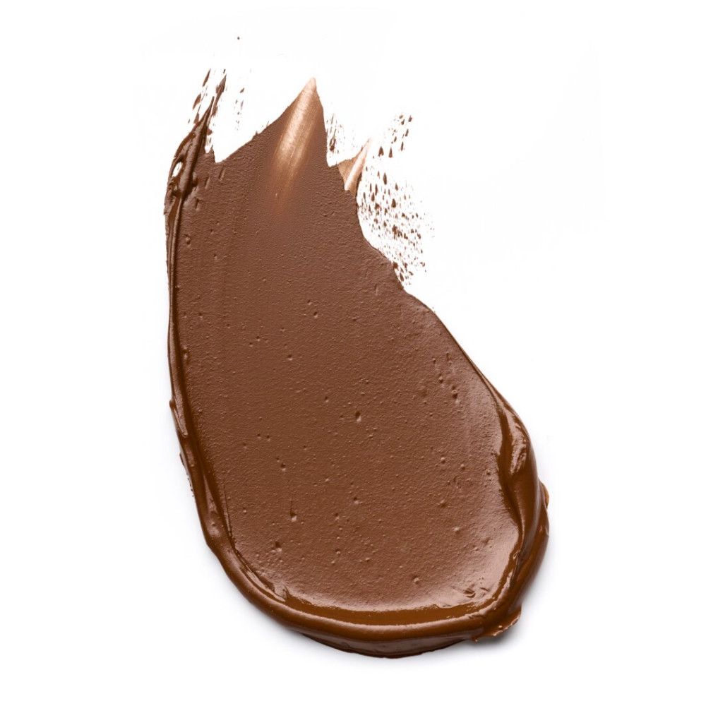 Uitgesmeerde foundation in donkerbruine tint. Textuur zichtbaar.