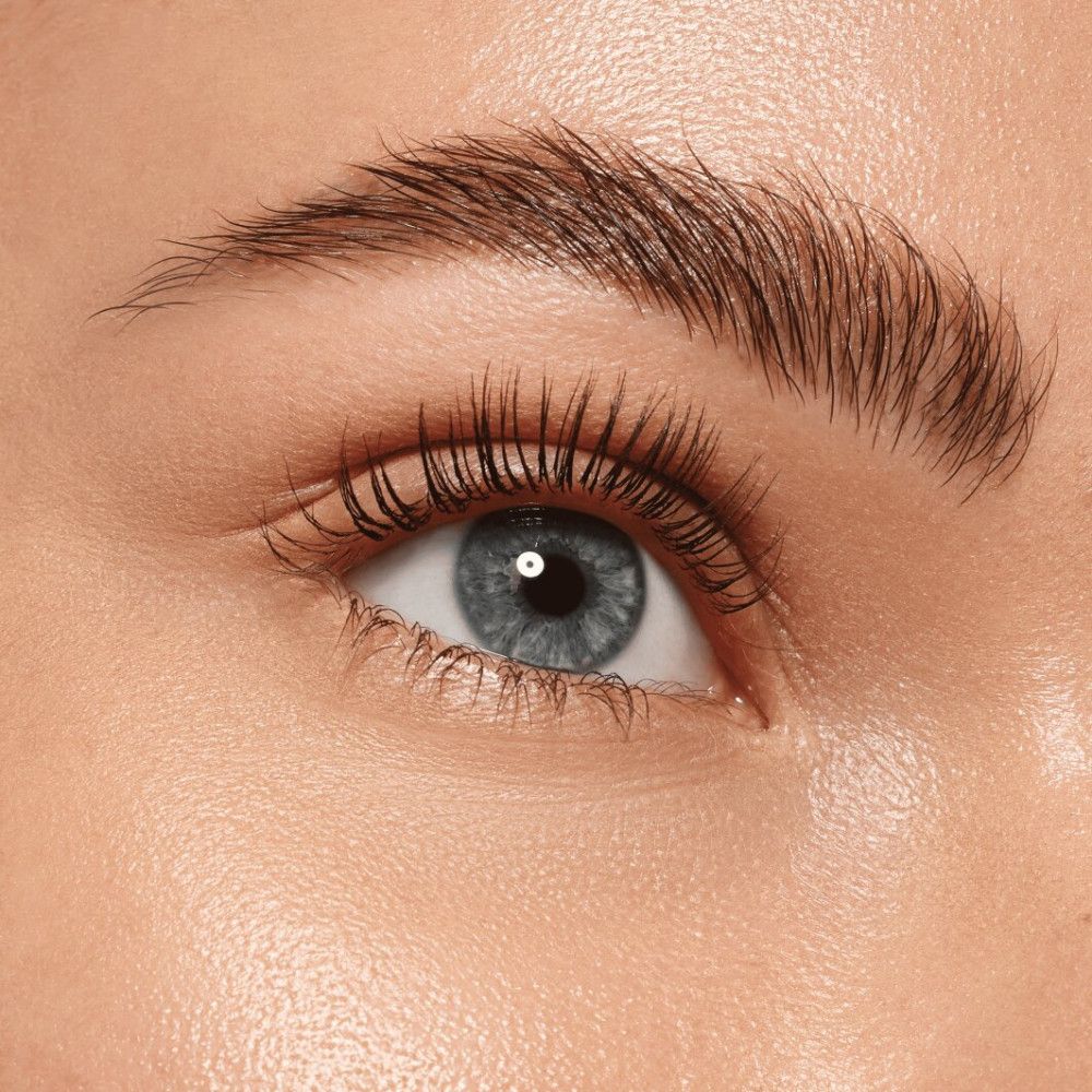 Close-up van een oog met opgemaakte wimpers. Het oog is blauw.