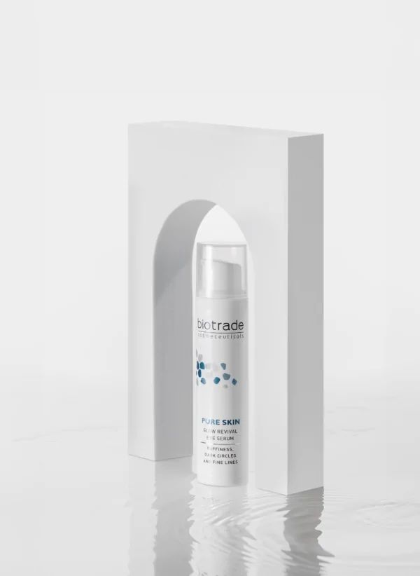 Flacon blanc Biotrade Pure Skin pour les yeux, motif bleu, placé dans une forme architecturale blanche. Couvercle transparent.