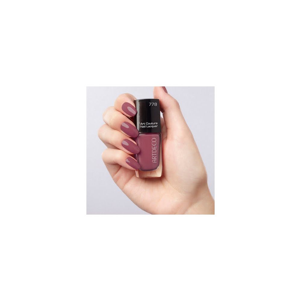 Flacon de vernis à ongles, couleur 778, tenu en main. Art Couture Nail Lacquer. Teinte rose-violet. Bouchon noir.