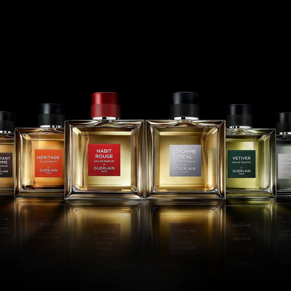 Rangée de flacons de parfum. Flacon "VETIVER" avec étiquette verte. Autres flacons avec étiquettes variées.