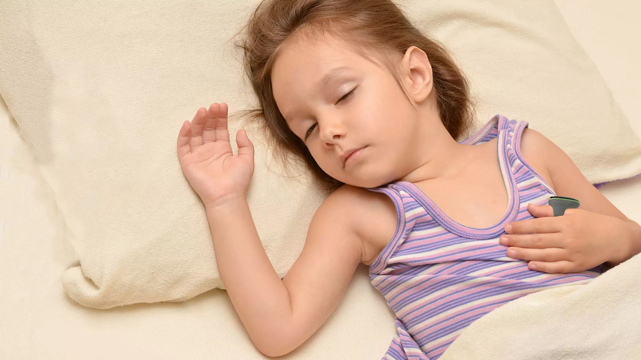 Enfant dormant avec un thermomètre sous le bras.