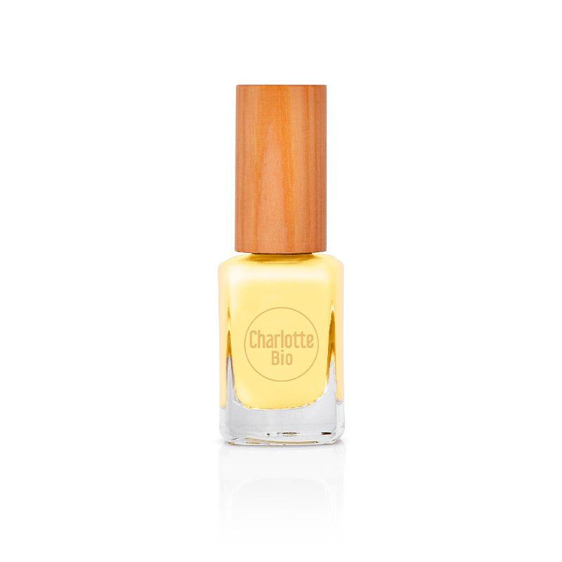 Gele nagellak in een glazen flesje met houten dop. De tekst "Charlotte Bio" is zichtbaar.