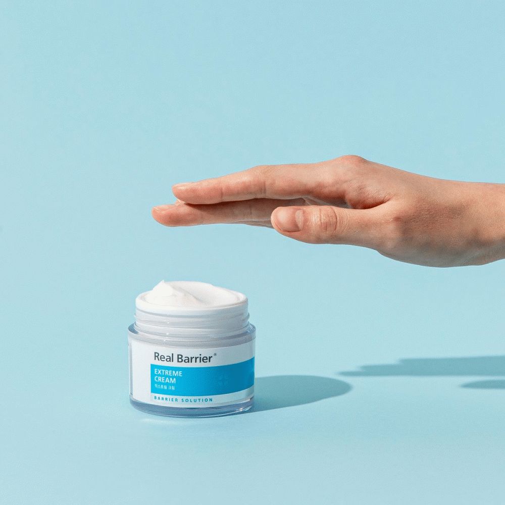 Hand reikt naar crèmepot. Blauwe en witte kleurstelling. Achtergrond: lichtblauw.