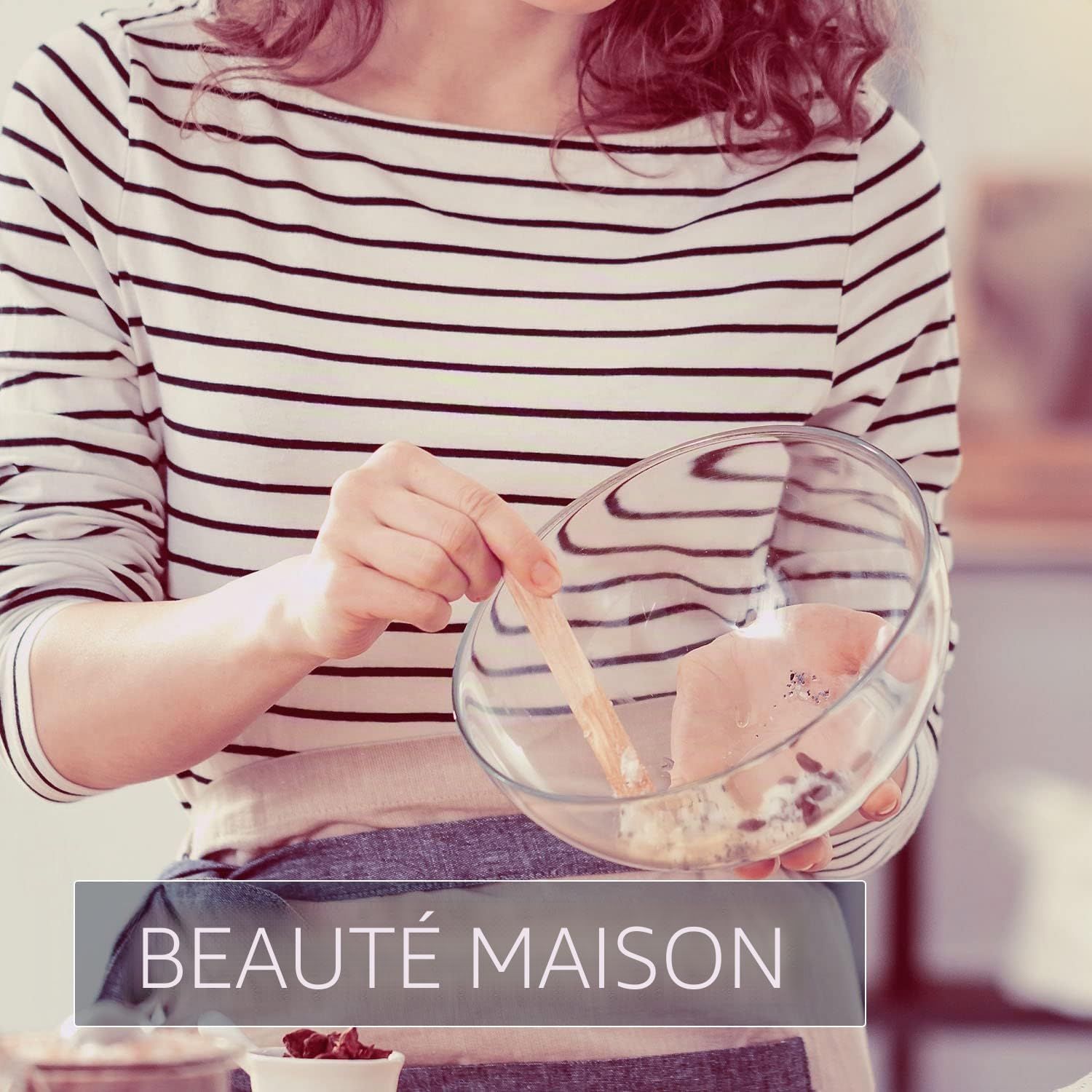 Femme mélangeant des ingrédients dans un bol en verre avec une spatule en bois.