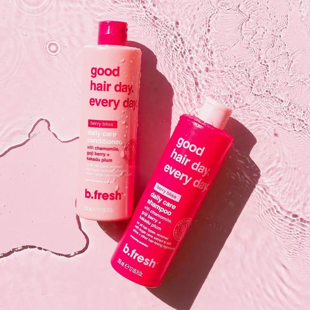 Twee shampoo flessen op roze oppervlak. Tekst: good hair day. every day. berry bliss daily care shampoo. b.fresh.