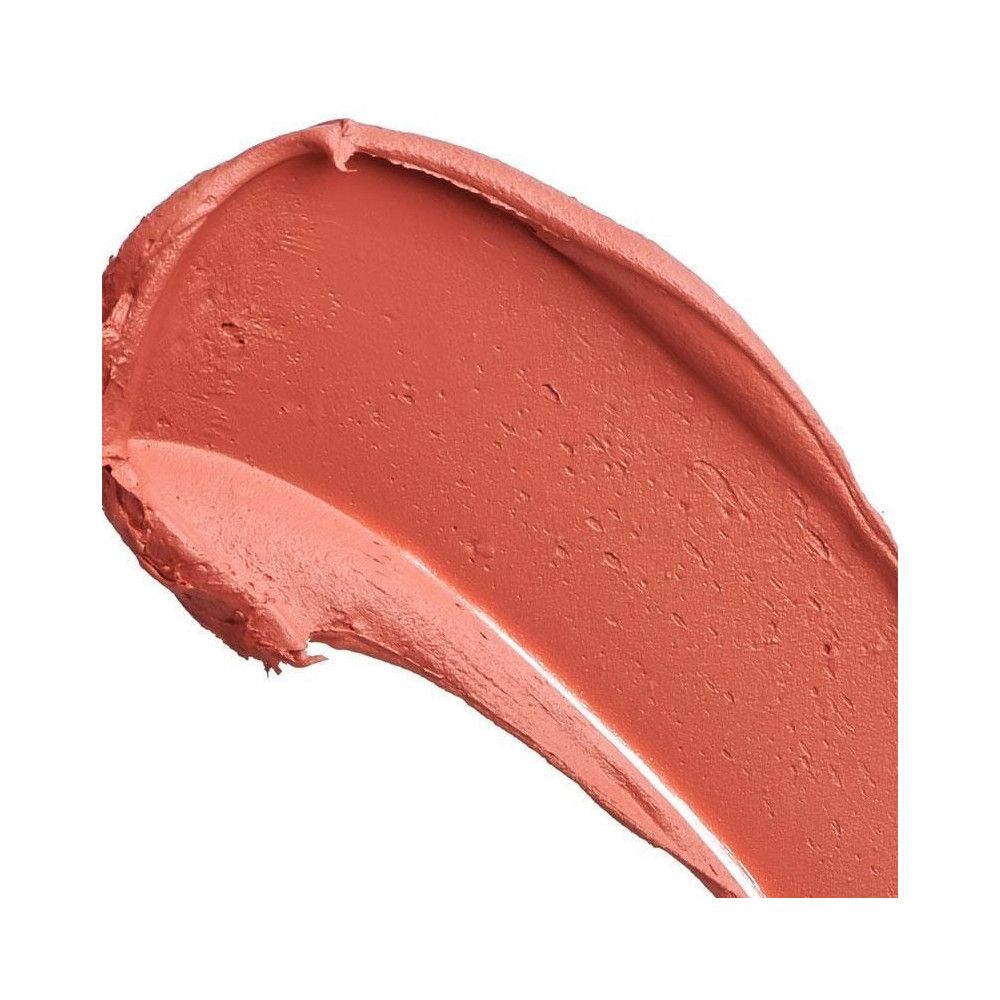 Gros plan d'une touche de rouge à lèvres. La couleur est une teinte corail mate.