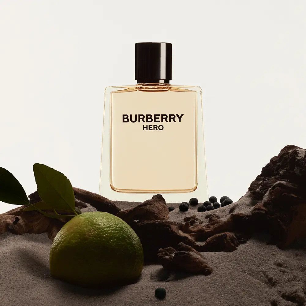 Burberry Hero Eau de Toilette. Flacon rectangulaire, bouchon noir. Inscription: Burberry Hero. Avec citron vert et bois.
