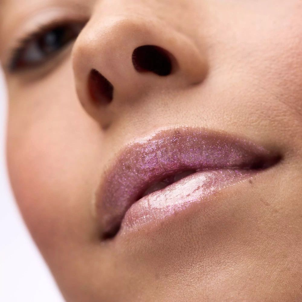 Close-up van lippen met lipgloss. De lippen zijn glanzend en roze.