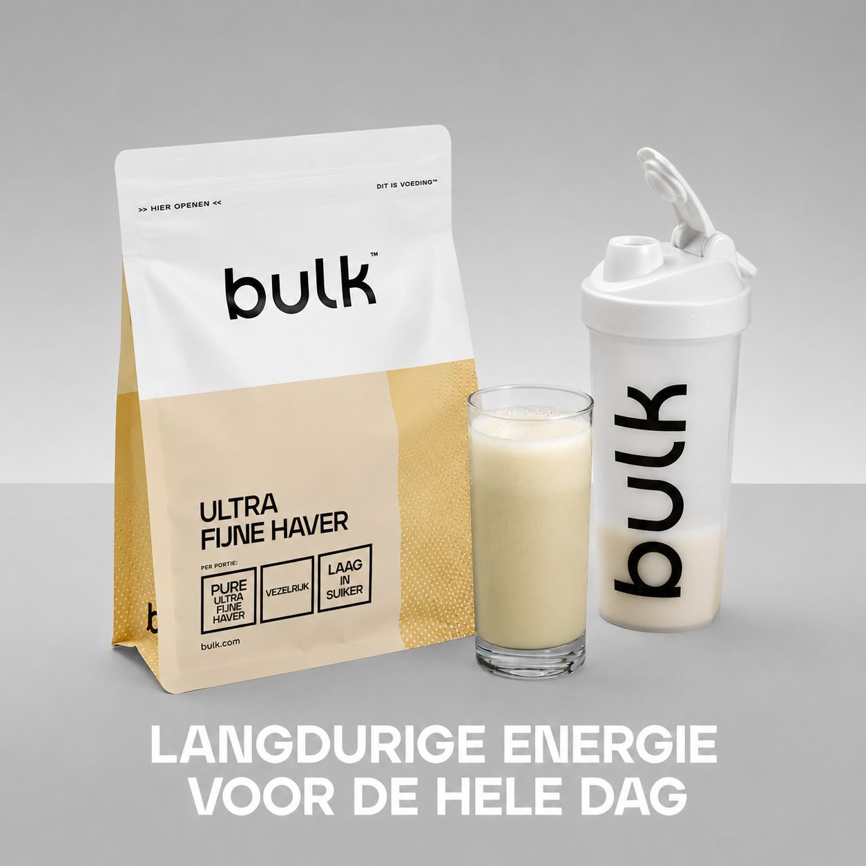 Bulk "Ultra Fijn Haver" poeder in wit-gele verpakking, ernaast een glas haverdrank en een witte Bulk shaker.
