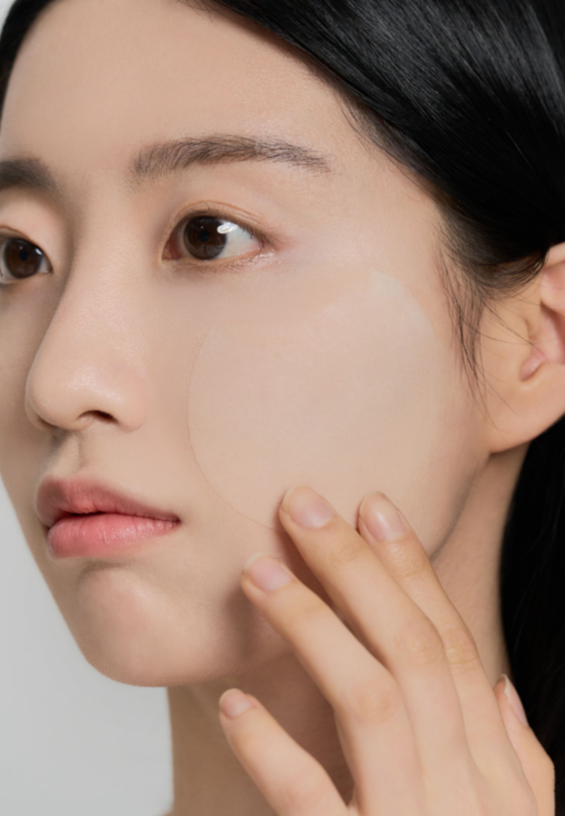 Vrouw met pad op wang. Pad is rond en transparant.