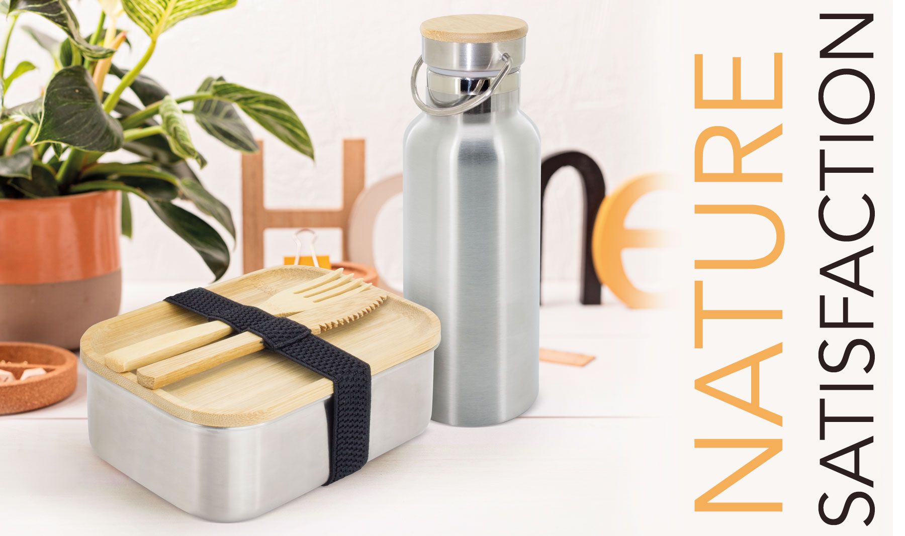 Productset met fles en lunchbox. Tekst: 'NATURE SATISFACTION'. Op een tafel met planten op de achtergrond.