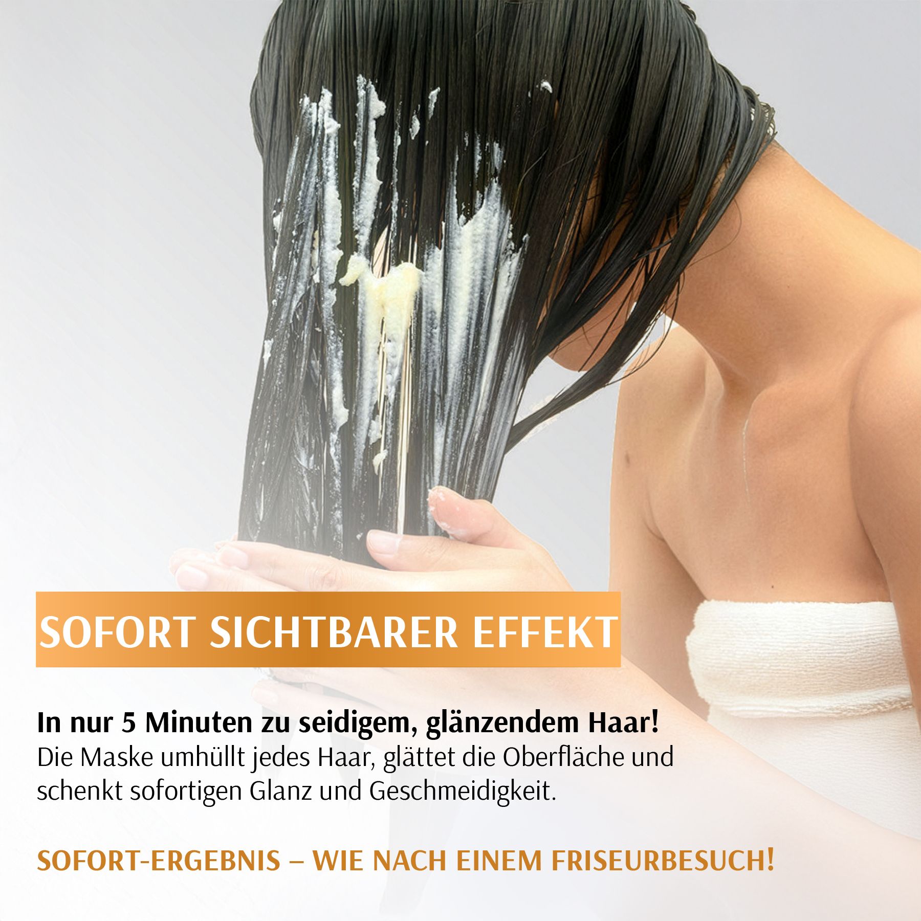 Een vrouw brengt een haarmasker aan op haar lange, donkere haar. Het witte masker is zichtbaar op de vochtige lokken.