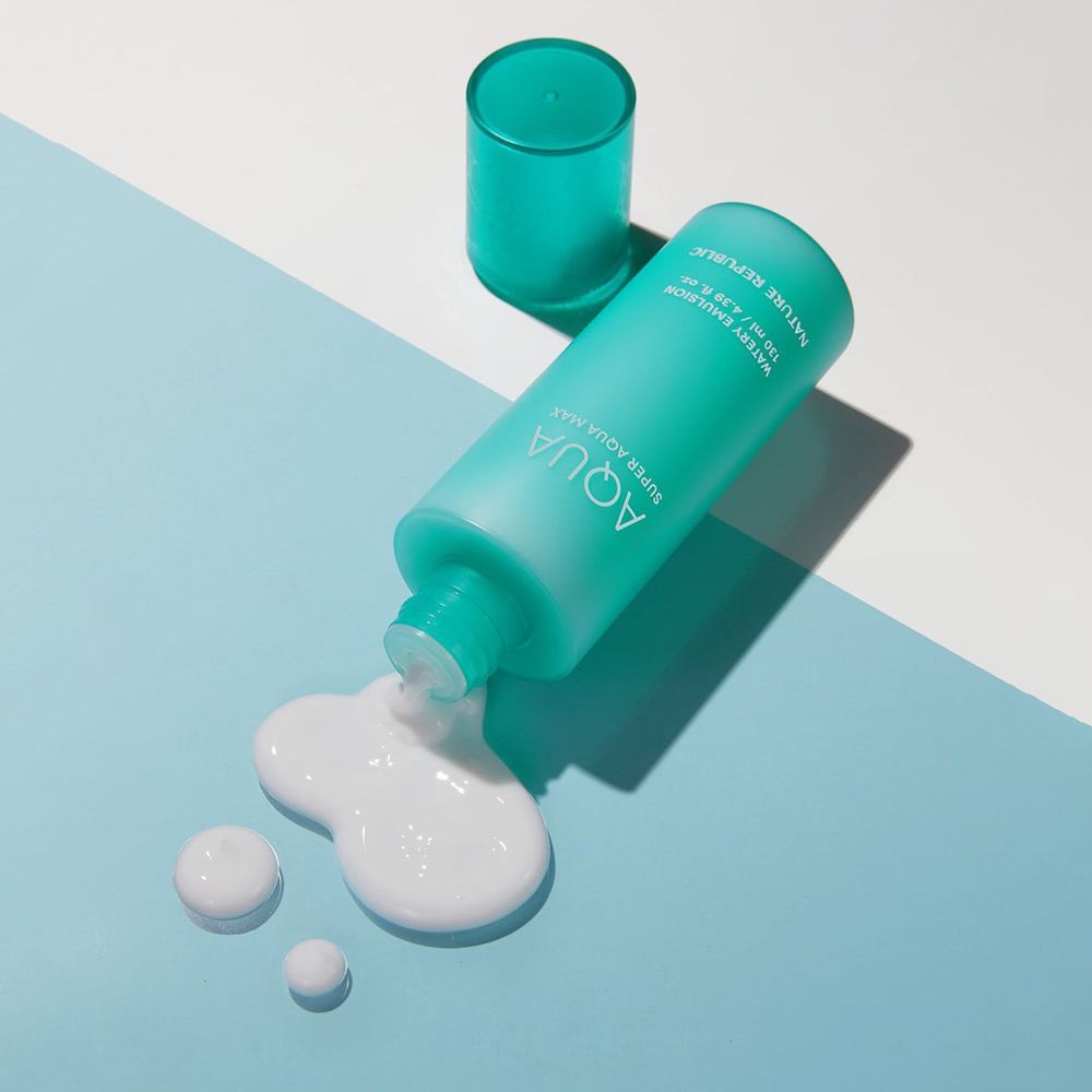 Bouteille turquoise avec émulsion blanche sur fond bleu. Couvercle à côté. Nom du produit visible.