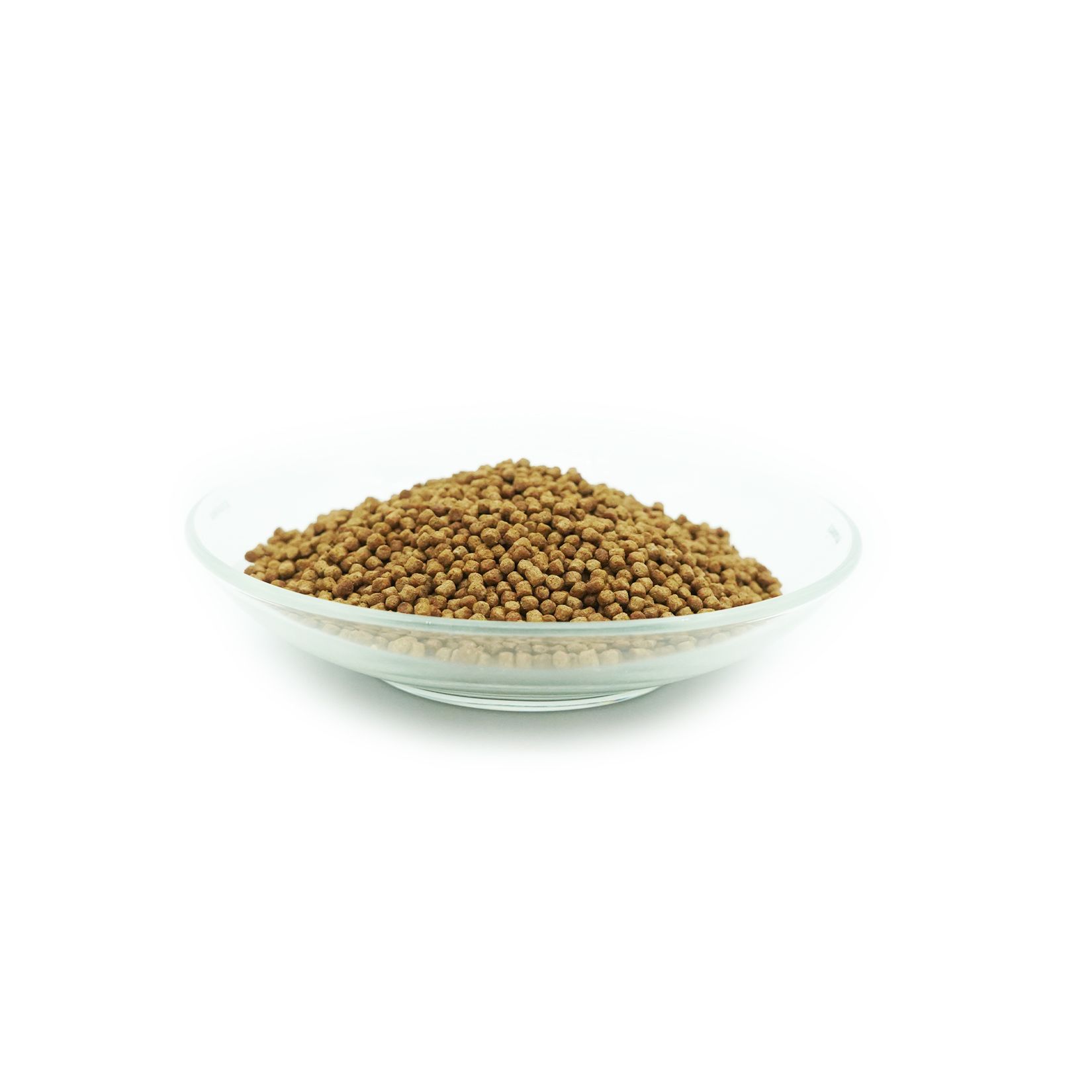 Aliments pour carpes koï bruns dans un bol en verre. Granulés ronds. Sur fond blanc.