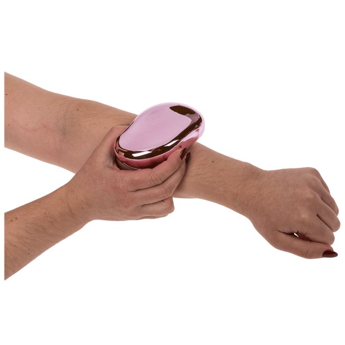 Épilateur rose ovale utilisé sur un bras.