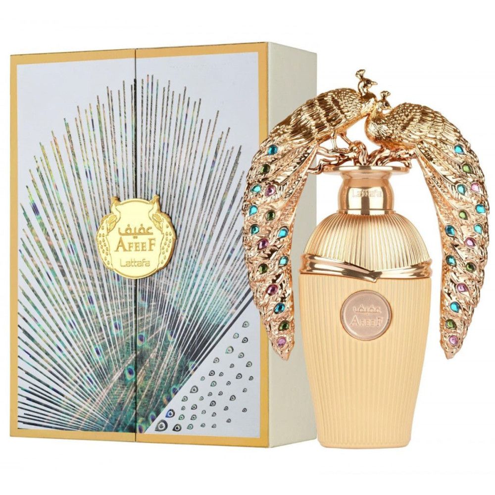 Flacon de parfum doré avec décorations de paons dorés et pierres précieuses colorées, à côté d'une boîte avec un motif de plumes de paon.