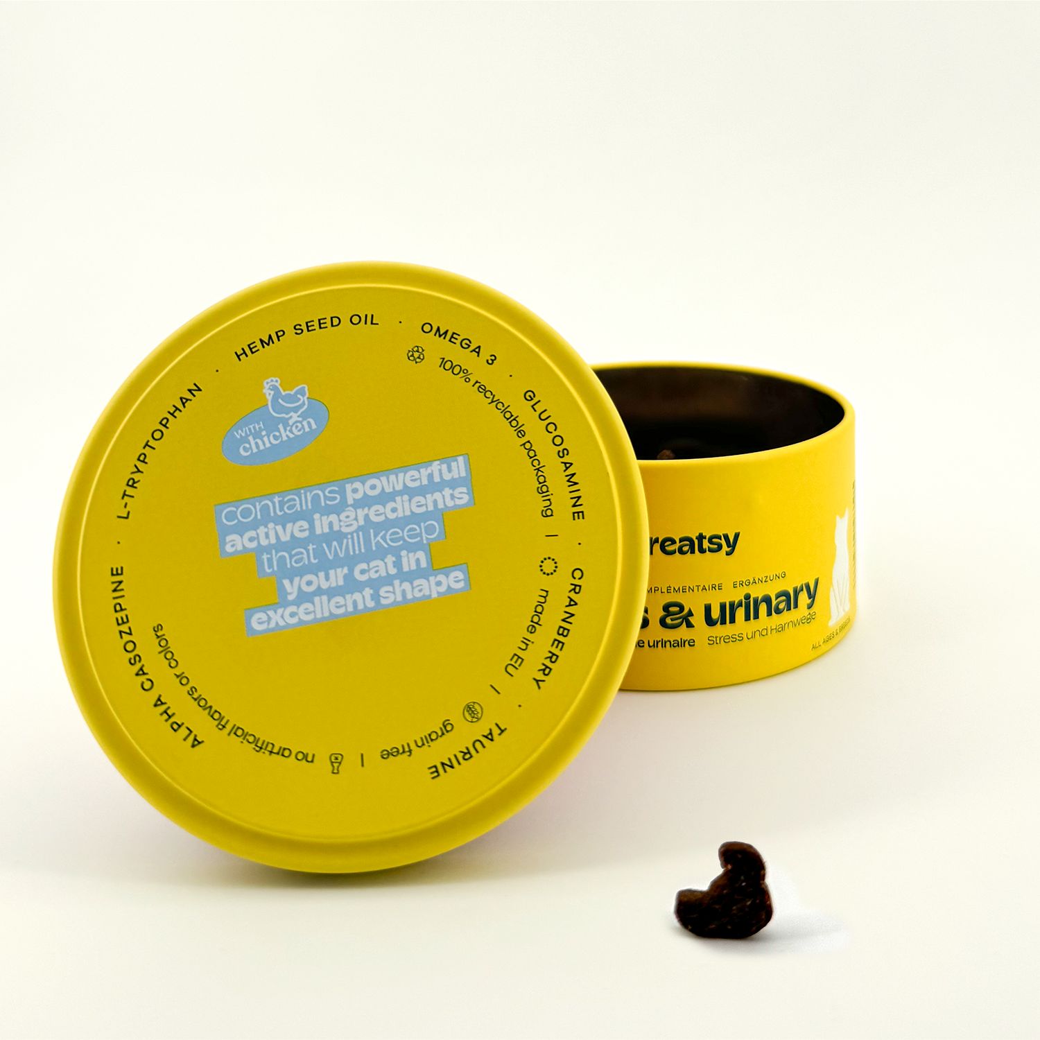 Boîte jaune « Treatsy Stress & Urinary ». Couvercle ouvert. Friandise à côté.
