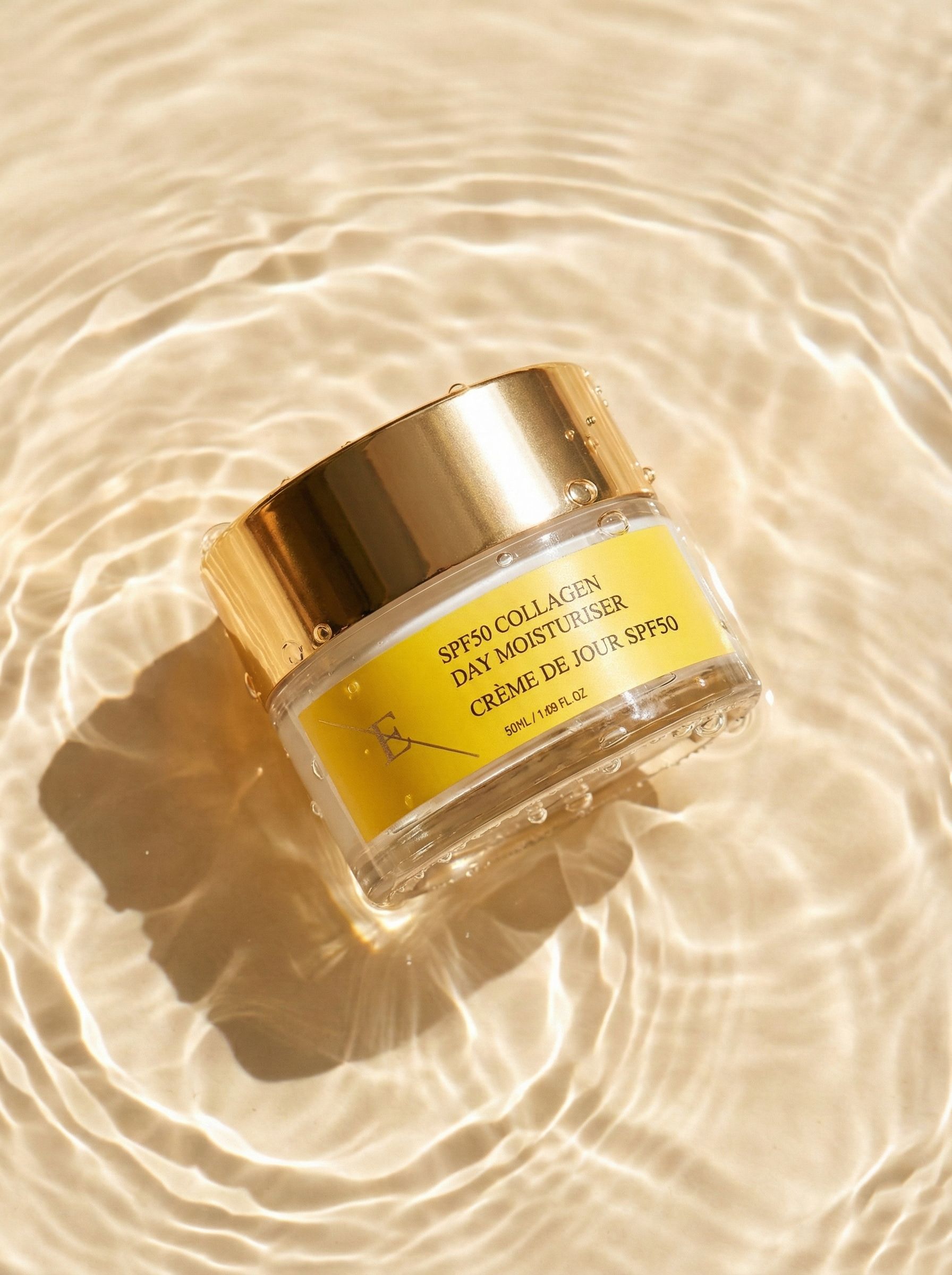 Pot de crème avec couvercle doré dans l'eau. Étiquette jaune avec texte: SPF50 Collagen Day Moisturiser, Crème de Jour SPF50. Ondulations.