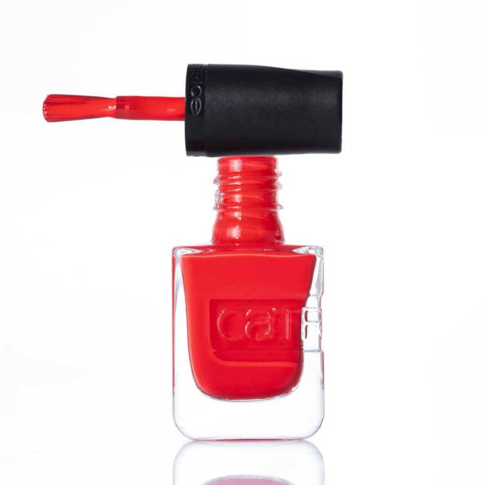Rode nagellak in een doorzichtige fles met zwarte dop en kwast.